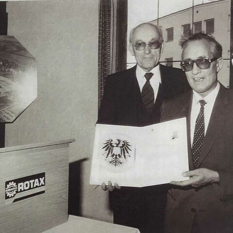 Karl Pötzlberger con el certificado con motivo de la entrega del Escudo Nacional, 1983 (BRP-Rotax)